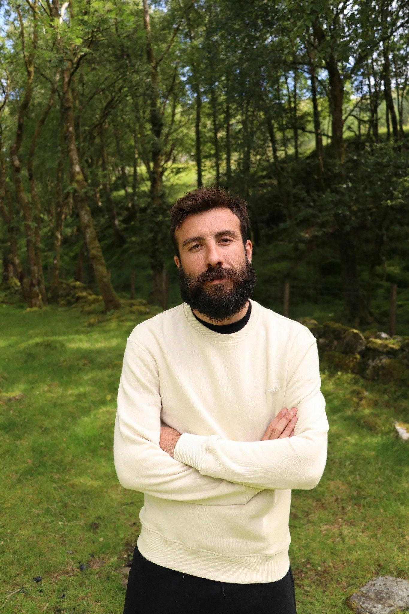 Michael, co-founder of hylo, standing in a woodland clearing with his arms crossed